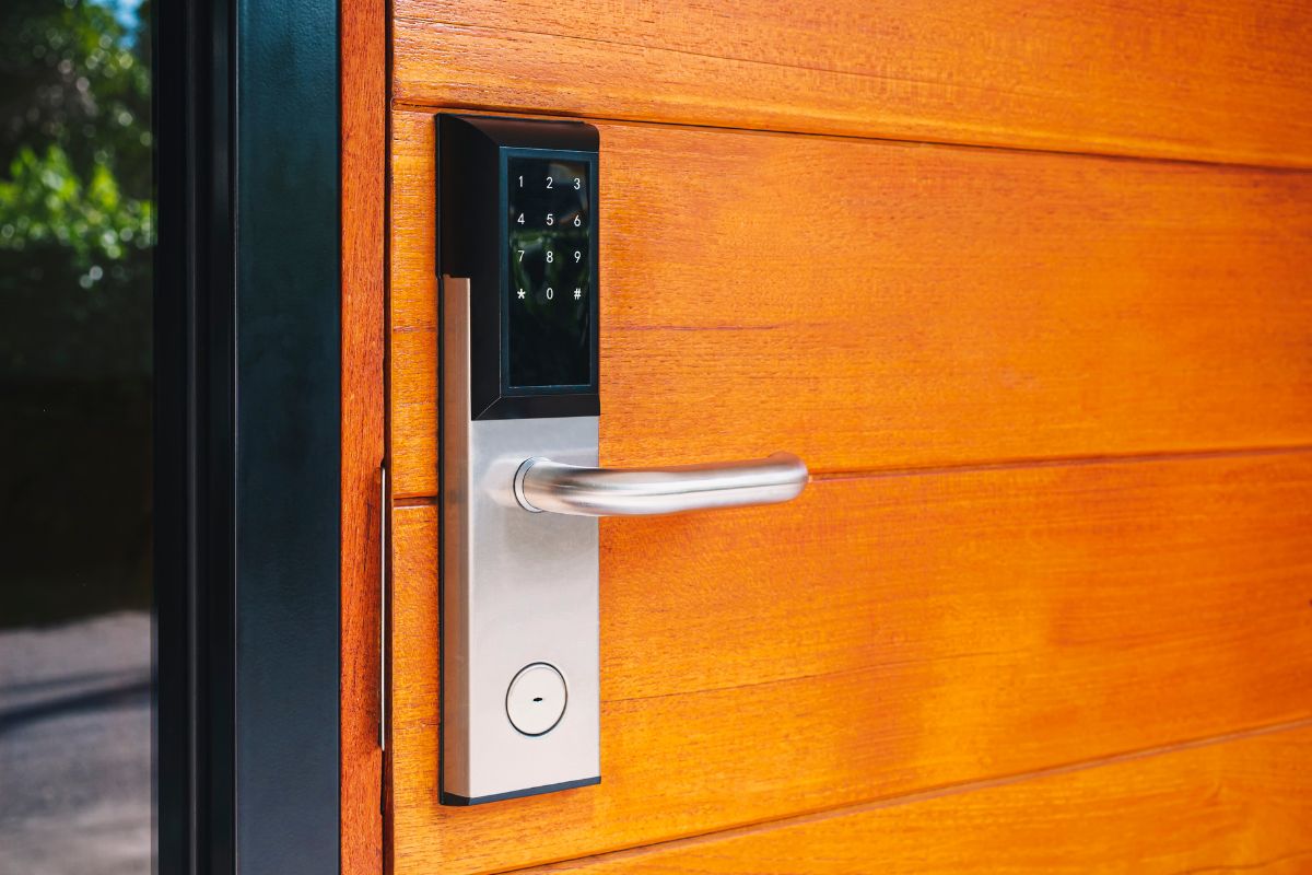  A close-up of a door handle on a wooden door featuring a modern digital lock mechanism.