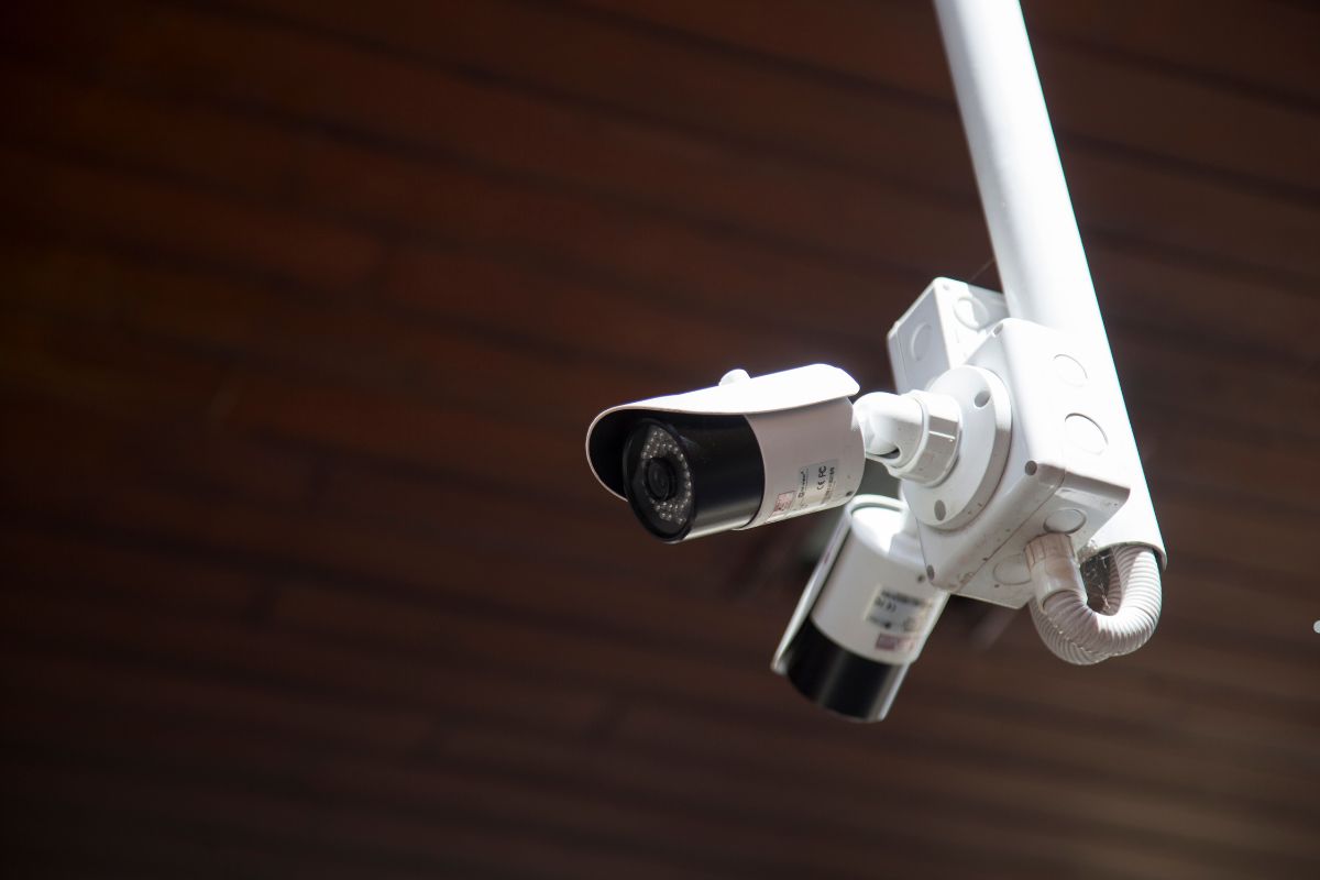 Close-up view of two security cameras mounted on a wall, showcasing their lenses and design details.
